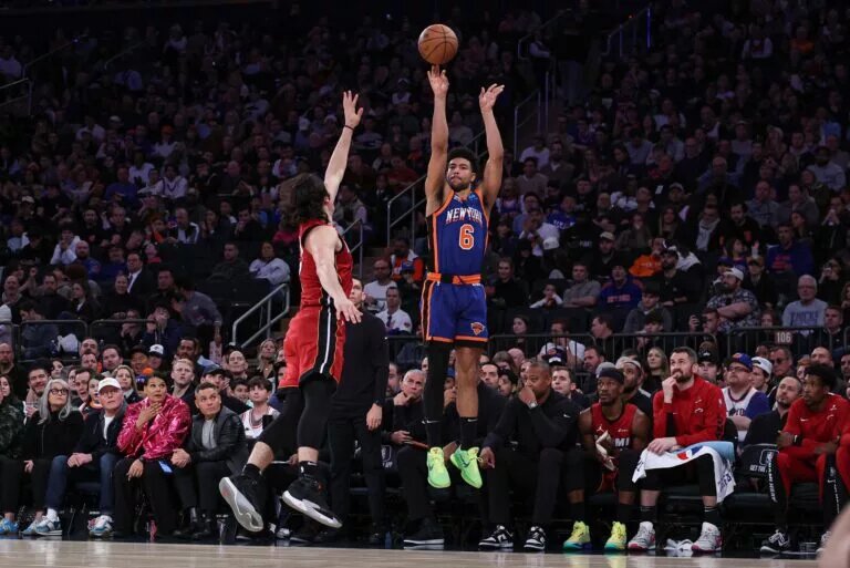 Jan 27, 2024; New York, New York, USA; New York Knicks guard Quentin Grimes (6) makes a three point basket as Miami Heat guard Jaime Jaquez Jr. (11) defends during the second half at Madison Square Garden. Mandatory Credit: Vincent Carchietta-USA TODAY Sports