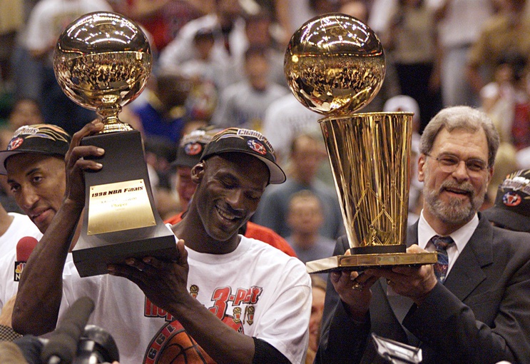 Chicago Bulls guard Michael Jordan holds the MVP trophy and coach Phil Jackson holds the championship trophy after the Bulls beat the Utah Jazz to win their 6th NBA title.