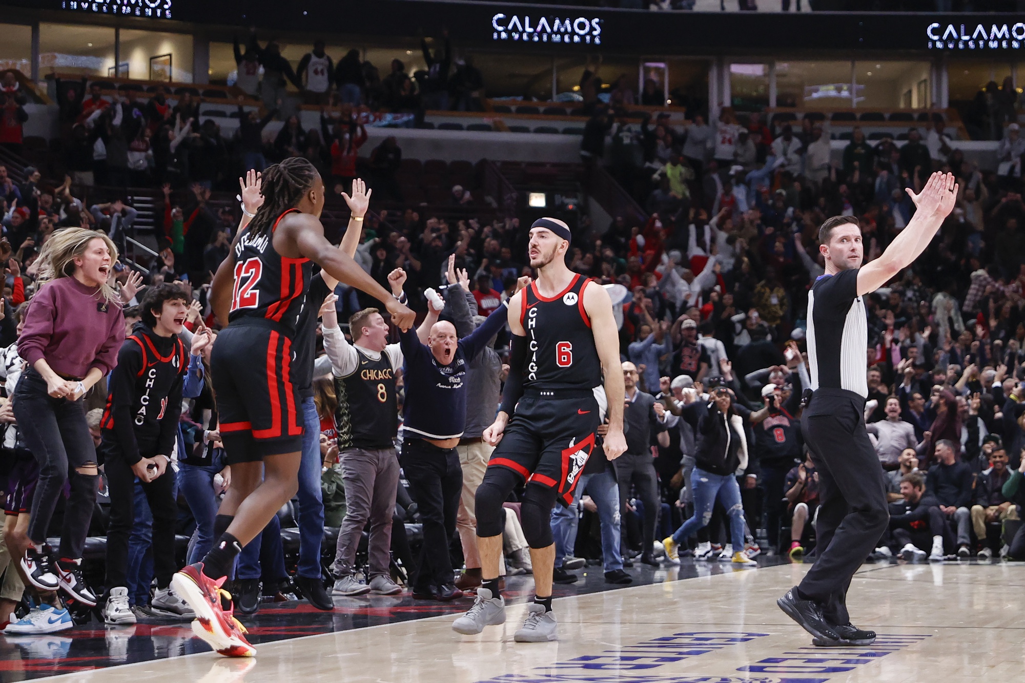 Chicago Bulls guard Alex Caruso (6) celebrates with guard Ayo Dosunmu (12) after shooting and scoring a three pointer at the end of regulation and sending the game against the Milwaukee Bucks into overtime at United Center.