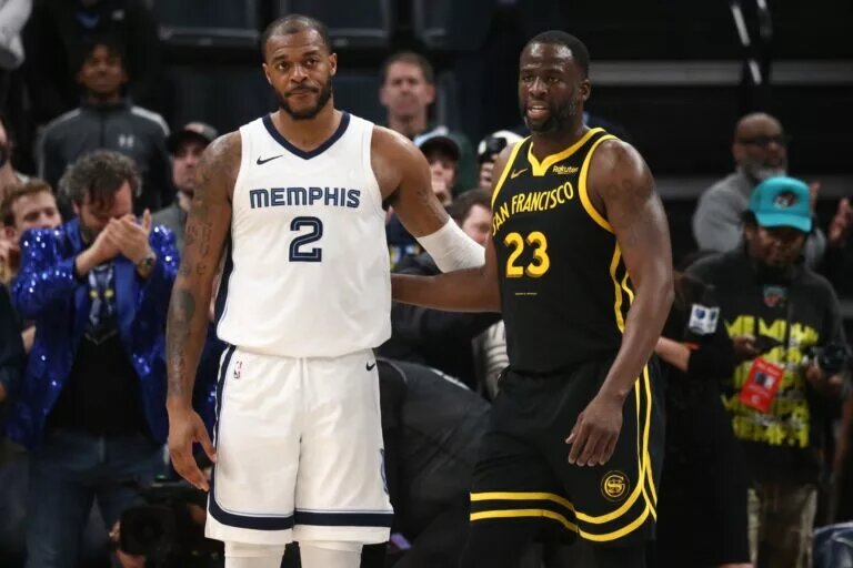 Jan 15, 2024; Memphis, Tennessee, USA; Memphis Grizzlies forward Xavier Tillman (2) and Golden State Warriors forward Draymond Green (23) embrace near the end of the second half at FedExForum. Mandatory Credit: Petre Thomas-USA TODAY Sports