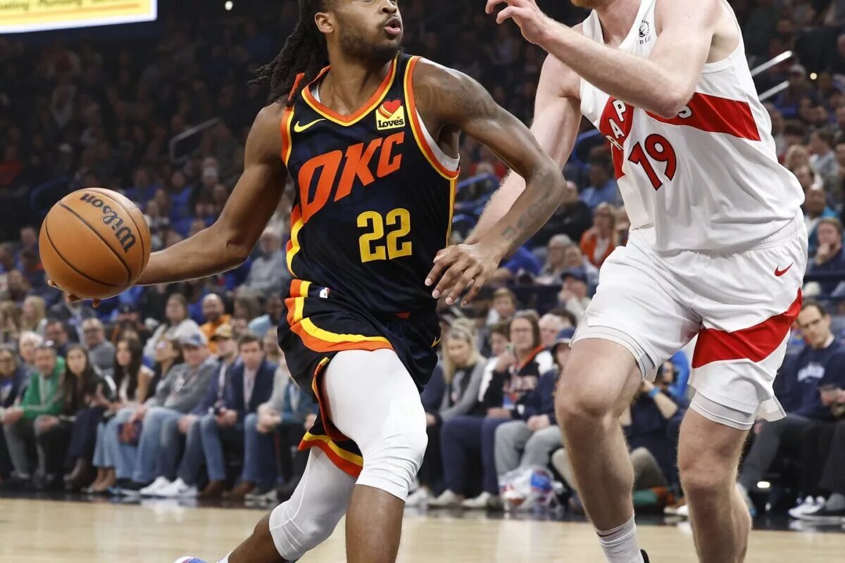 Oklahoma City Thunder guard Cason Wallace (22) drives to the basket beside Toronto Raptors center Jakob Poeltl (19) during the first quarter at Paycom Center.