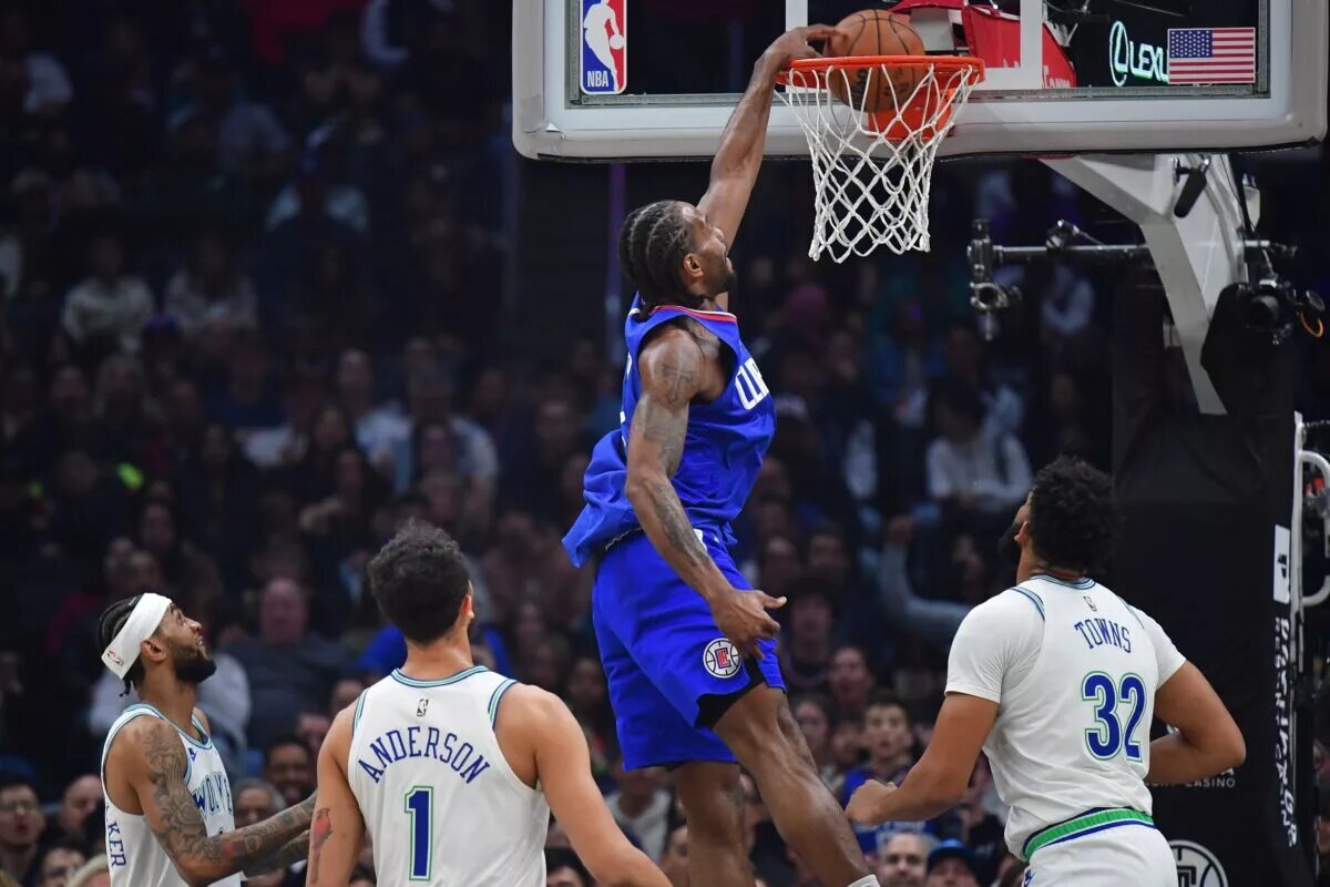 Los Angeles Clippers forward Kawhi Leonard (2) dunks for the basket against Minnesota Timberwolves center Karl-Anthony Towns (32) and forward Kyle Anderson (1) during the first half at Crypto.com Arena.