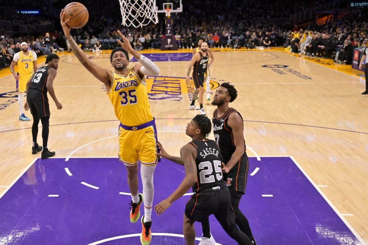 Feb 13, 2024; Los Angeles, California, USA; Los Angeles Lakers forward Christian Wood (35) drives past Detroit Pistons guard Marcus Sasser (25) and guard Troy Brown, Jr. in the first half at Crypto.com Arena. Mandatory Credit: Jayne Kamin-Oncea-USA TODAY Sports