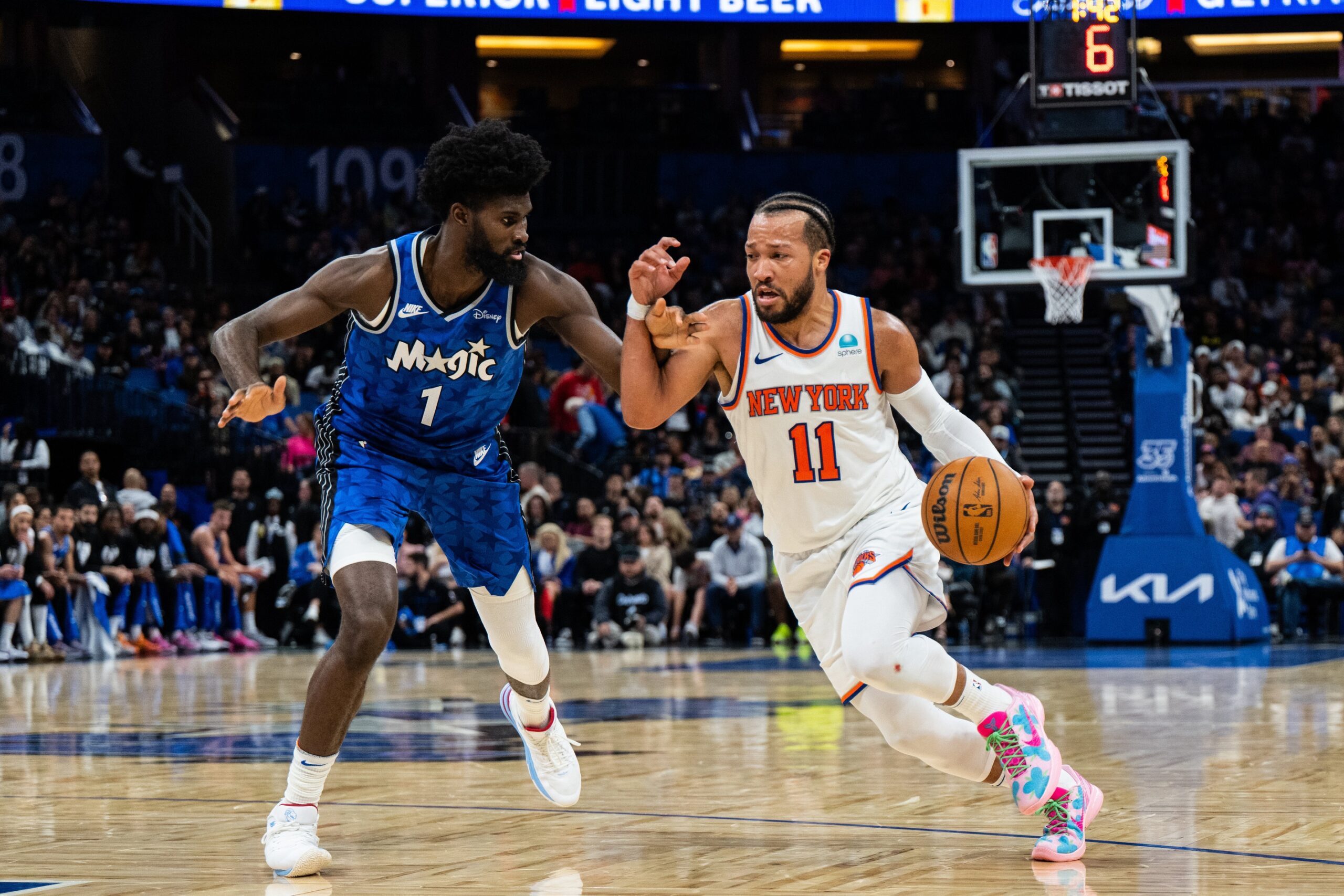 Feb 14, 2024; Orlando, Florida, USA; New York Knicks guard Jalen Brunson (11) dribbles the ball against Orlando Magic forward Jonathan Isaac (1) in the second quarter at KIA Center. Mandatory Credit: Jeremy Reper-USA TODAY Sports