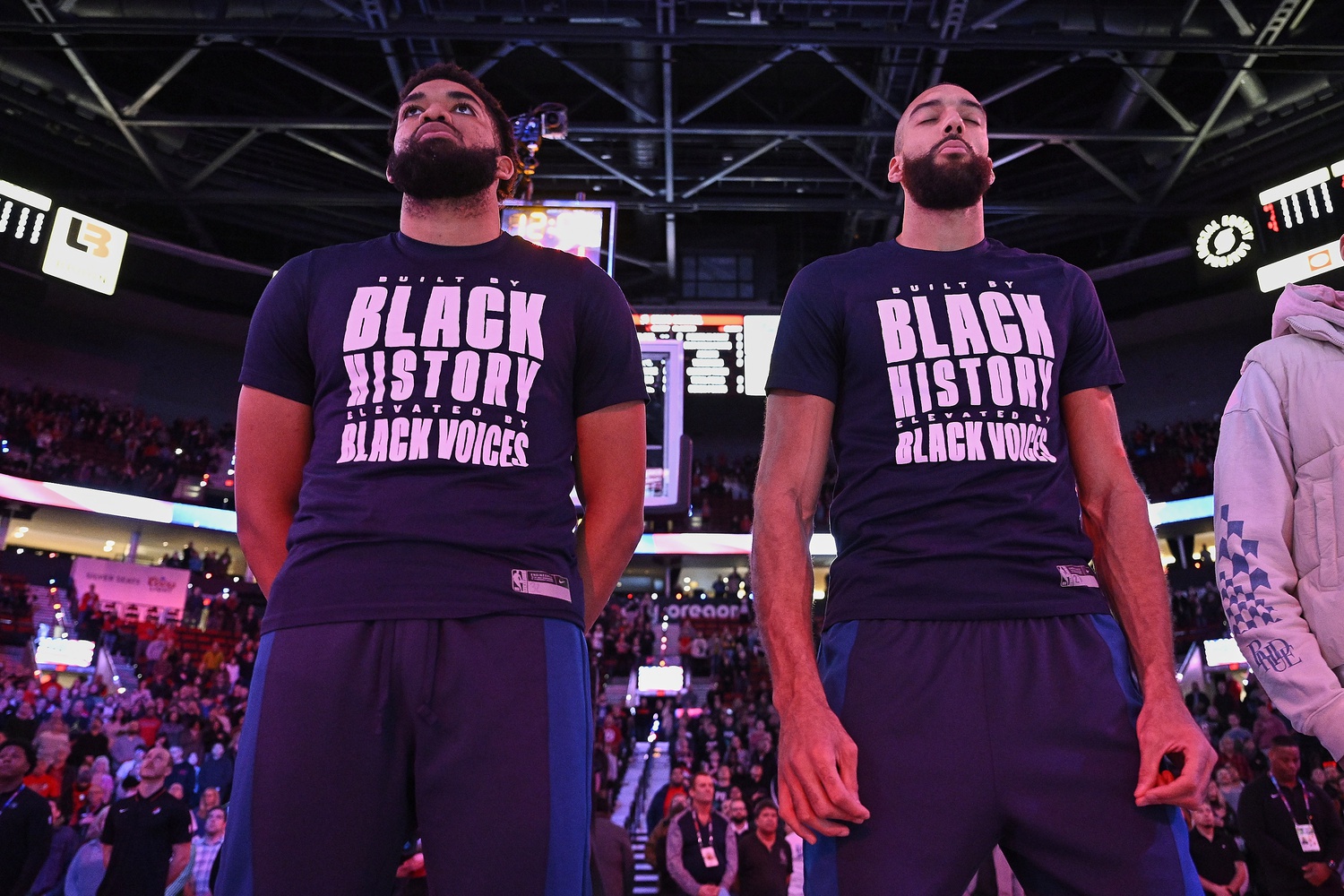 Minnesota Timberwolves center Karl-Anthony Towns (32), left, and center Rudy Gobert (27) stand during the singing of the national anthem before a game against the Portland Trail Blazers at Moda Center.