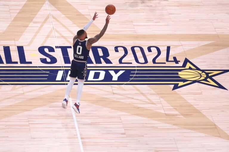 Eastern Conference guard Damian Lillard (0) of the Milwaukee Bucks makes a three point basket from half court against the Western Conference All-Stars during the fourth quarter in the 73rd NBA All Star game at Gainbridge Fieldhouse.