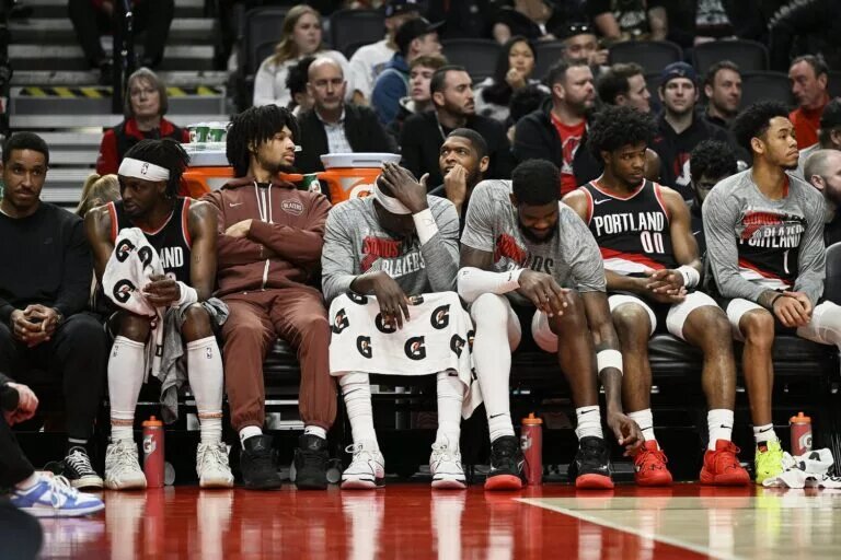 Blazers center Deandre Ayton sits in middle of teammates on bench