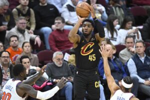 Cleveland Cavaliers guard Donovan Mitchell shoots ball over New York Knicks defenders