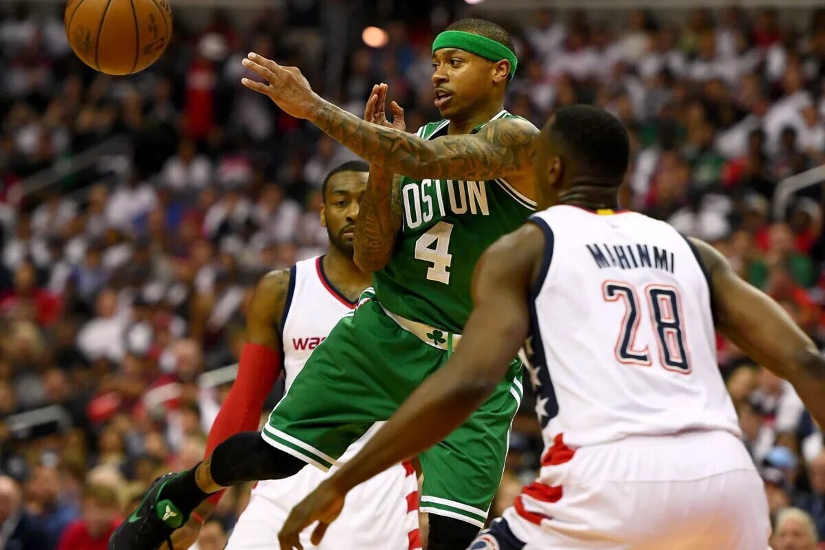 Boston Celtics guard Isaiah Thomas (4) passes the ball between Washington Wizards center Ian Mahinmi (28) and guard John Wall (2) during the second quarter in game four of the second round of the 2017 NBA Playoffs at Verizon Center.