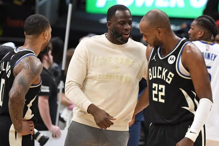 Khris Middleton of the Milwaukee Bucks with teammate Damian Lillard and Golden State Warriors forward Draymond Green