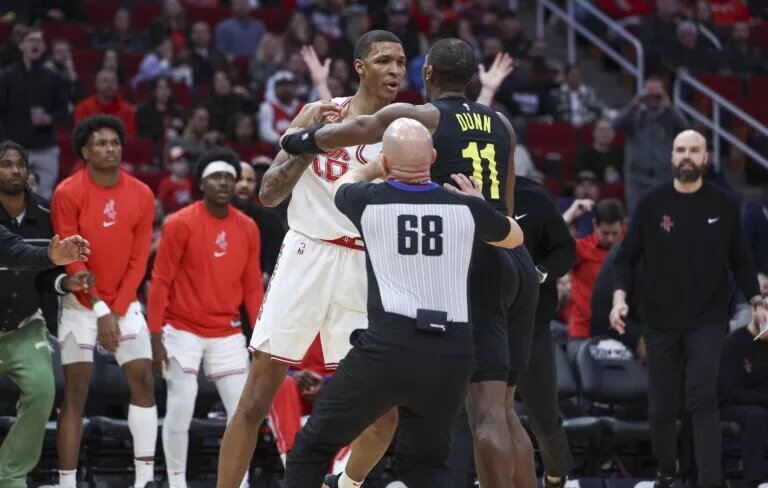 Jan 20, 2024; Houston, Texas, USA; Houston Rockets forward Jabari Smith Jr. (10) and Utah Jazz guard Kris Dunn (11) exchange words during the third quarter at Toyota Center. Mandatory Credit: Troy Taormina-USA TODAY Sports