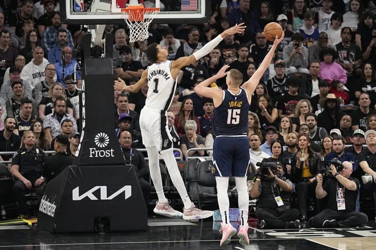 Denver Nuggets center Nikola Jokic attempts to make a hook shot over San Antonio Spurs center Victor Wembanyama
