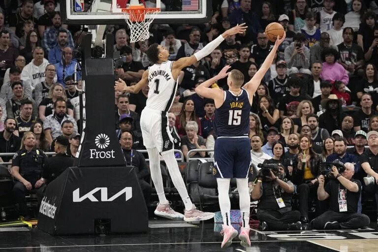 Denver Nuggets center Nikola Jokic attempts to make a hook shot over San Antonio Spurs center Victor Wembanyama