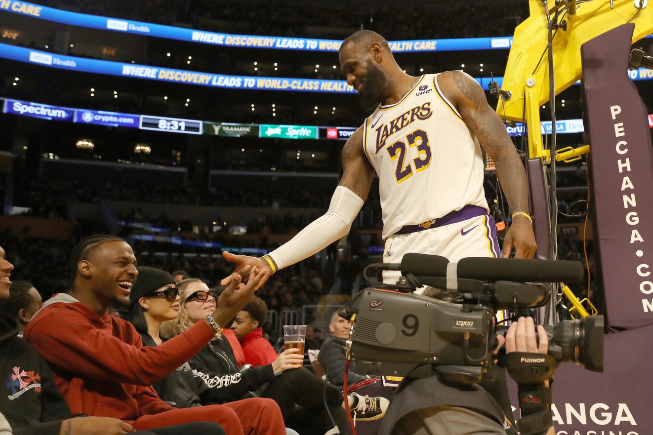 USC wing Bronny James shakes hands with father LeBron James at NBA game