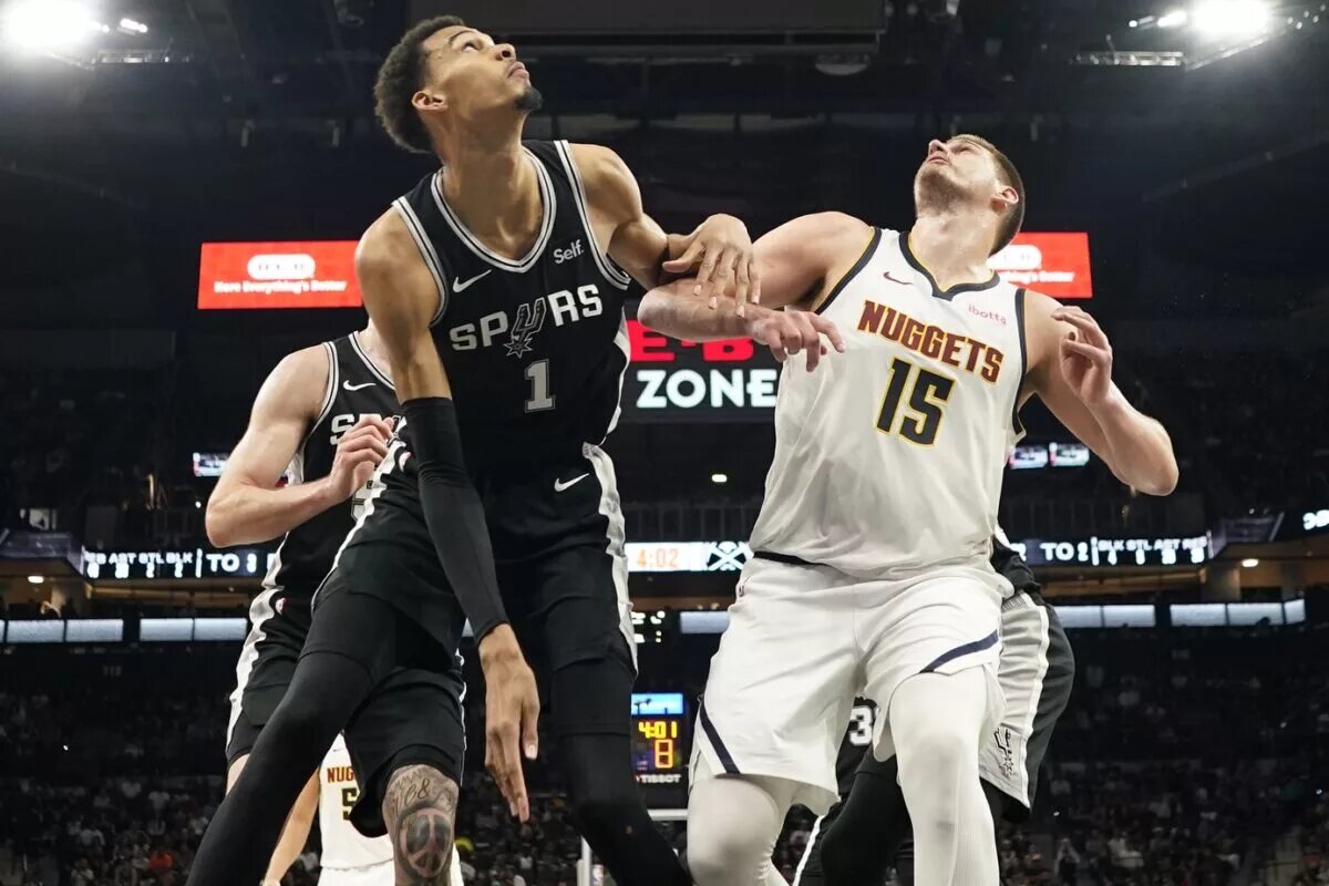 San Antonio Spurs big man Victor Wembanyama and Denver Nuggets center Nikola Jokic battle for a rebound