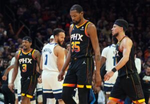 Phoenix Suns superstar Kevin Durant surrounded by teammates