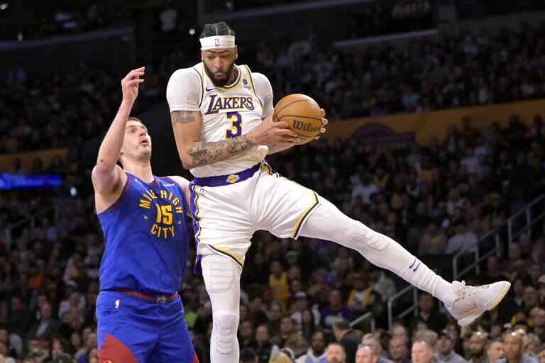 Mar 2, 2024; Los Angeles, California, USA; Los Angeles Lakers forward Anthony Davis (3) grabs a rebound in front of Denver Nuggets center Nikola Jokic (15) in the first half at Crypto.com Arena. Mandatory Credit: Jayne Kamin-Oncea-USA TODAY Sports