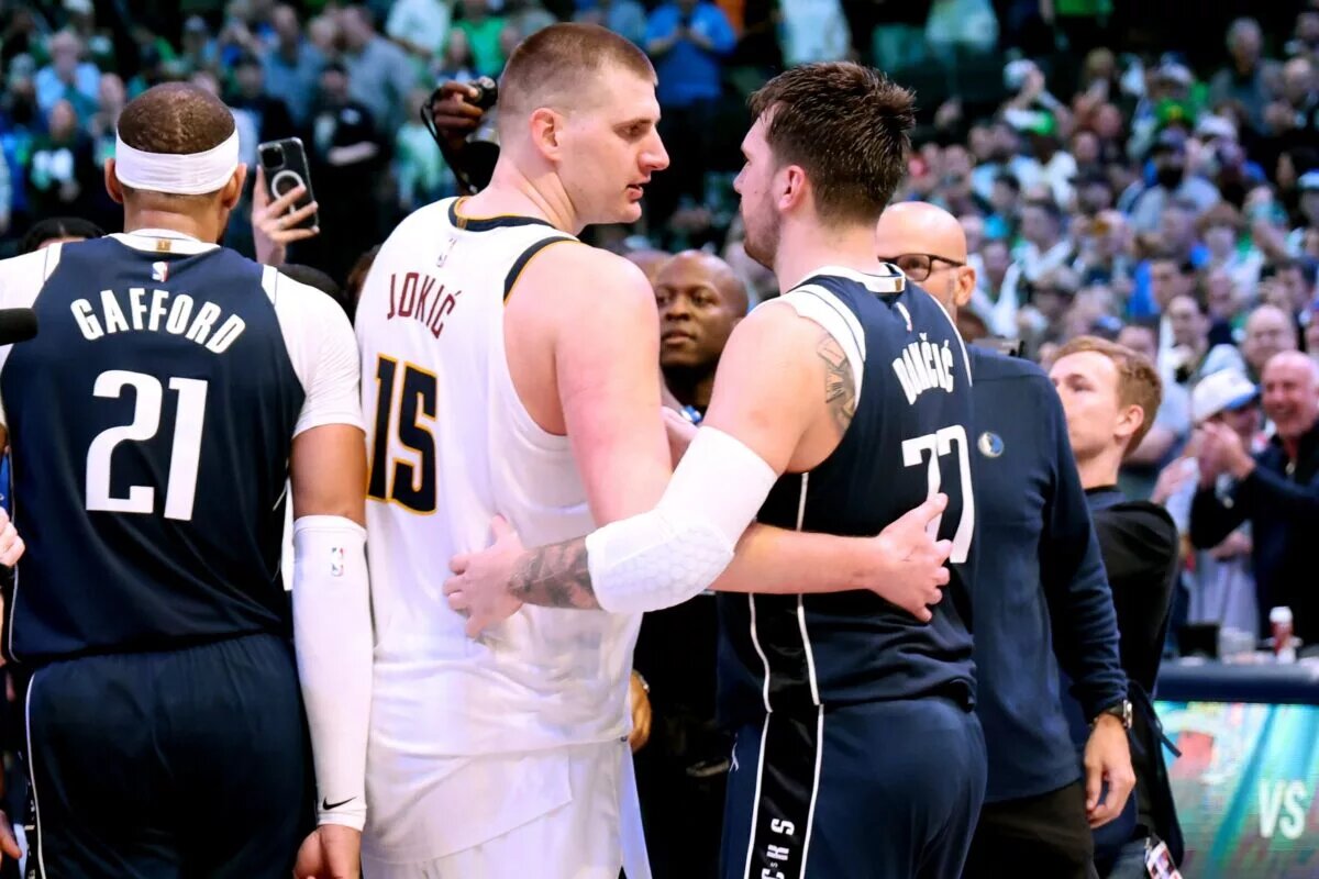Denver Nuggets center Nikola Jokic (15) hugs Dallas Mavericks guard Luka Doncic (77) after the game at American Airlines Center.