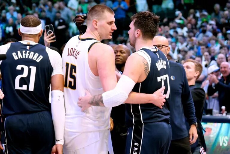 Denver Nuggets center Nikola Jokic (15) hugs Dallas Mavericks guard Luka Doncic (77) after the game at American Airlines Center.