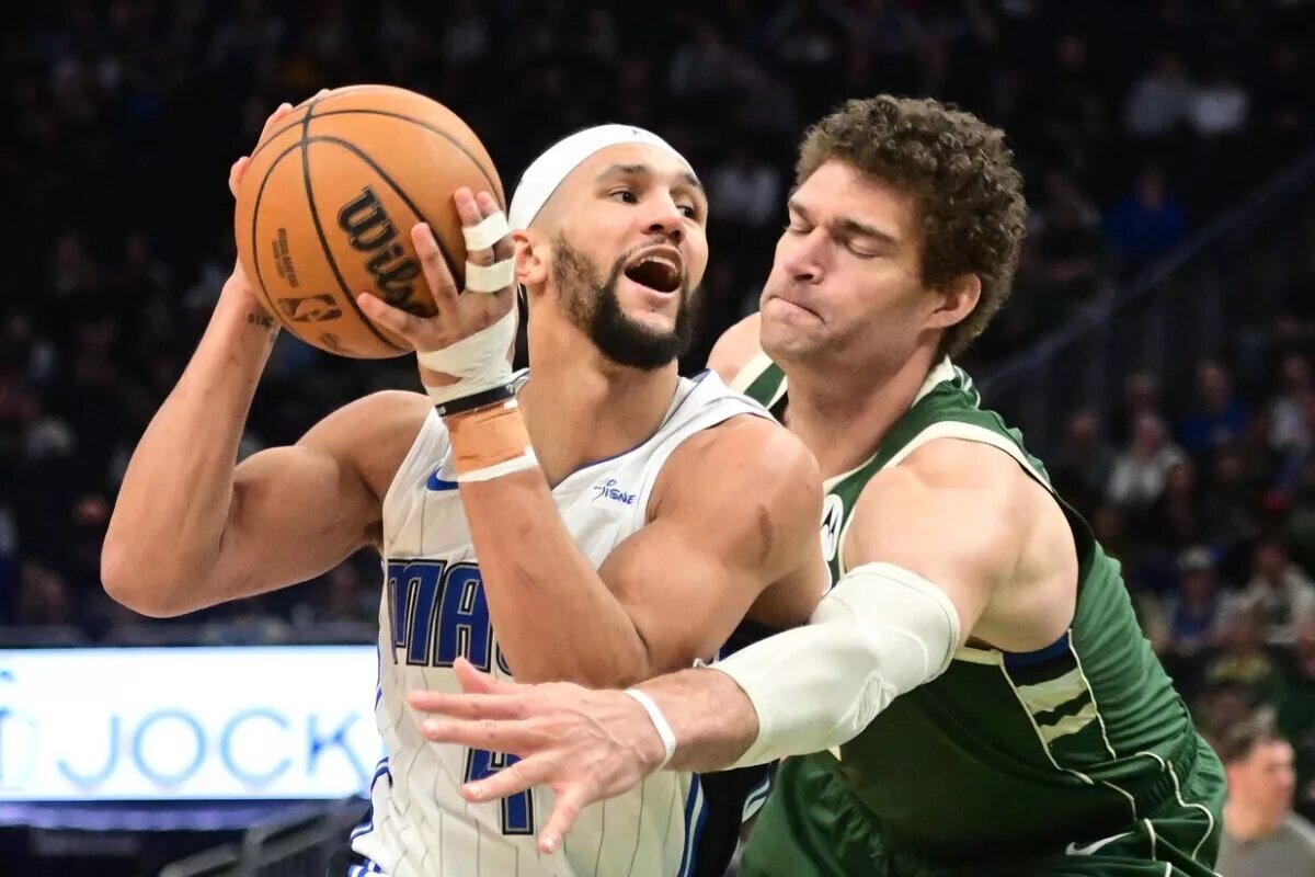 Apr 10, 2024; Milwaukee, Wisconsin, USA; Orlando Magic guard Jalen Suggs (4) drives past Milwaukee Bucks center Brook Lopez (11) in the fourth quarter at Fiserv Forum. Mandatory Credit: Benny Sieu-USA TODAY Sports