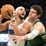 Apr 10, 2024; Milwaukee, Wisconsin, USA; Orlando Magic guard Jalen Suggs (4) drives past Milwaukee Bucks center Brook Lopez (11) in the fourth quarter at Fiserv Forum. Mandatory Credit: Benny Sieu-USA TODAY Sports