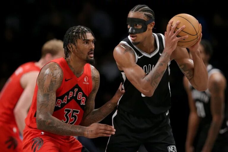 Apr 10, 2024; Brooklyn, New York, USA; Brooklyn Nets center Nic Claxton (33) controls the ball against Toronto Raptors center Malik Williams (35) during the third quarter at Barclays Center. Mandatory Credit: Brad Penner-USA TODAY Sports