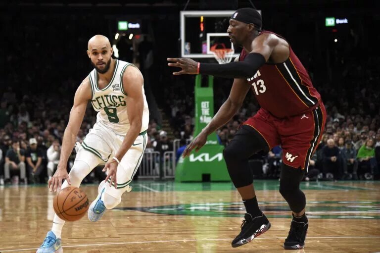 Apr 21, 2024; Boston, Massachusetts, USA; Boston Celtics guard Derrick White (9) controls the ball while Miami Heat center Bam Adebayo (13) defends during the second half in game one of the first round for the 2024 NBA playoffs at TD Garden. Mandatory Credit: Bob DeChiara-USA TODAY Sports