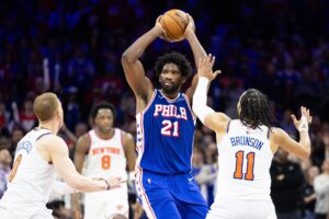 Philadelphia 76ers center Joel Embiid (21) controls the ball in front of New York Knicks guard Jalen Brunson (11) and guard Donte DiVincenzo (0) during the second half of game three of the first round for the 2024 NBA playoffs at Wells Fargo Center.