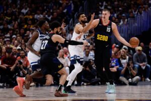 Denver Nuggets star Nikola Jokic tries to get ball to teammate while facing Minnesota Timberwolves defense
