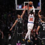 Jan 23, 2024; Brooklyn, New York, USA; New York Knicks forward Julius Randle (30) dunks against Brooklyn Nets center Nic Claxton (33) and guard Dennis Smith Jr. (4) and forward Cameron Johnson (2) in front of Knicks guard Jalen Brunson (11) during the fourth quarter at Barclays Center. Mandatory Credit: Brad Penner-USA TODAY Sports