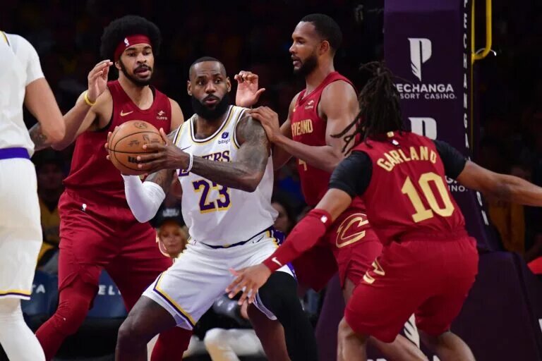 Cleveland Cavaliers players Darius Garland, Evan Mobley, and Jarrett Allen surround LeBron James