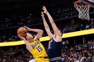 Apr 29, 2024; Denver, Colorado, USA; Los Angeles Lakers guard Austin Reaves (15) drives to the net against Denver Nuggets center Nikola Jokic (15) in the first quarter during game five of the first round for the 2024 NBA playoffs at Ball Arena. Mandatory Credit: Isaiah J. Downing-USA TODAY Sports