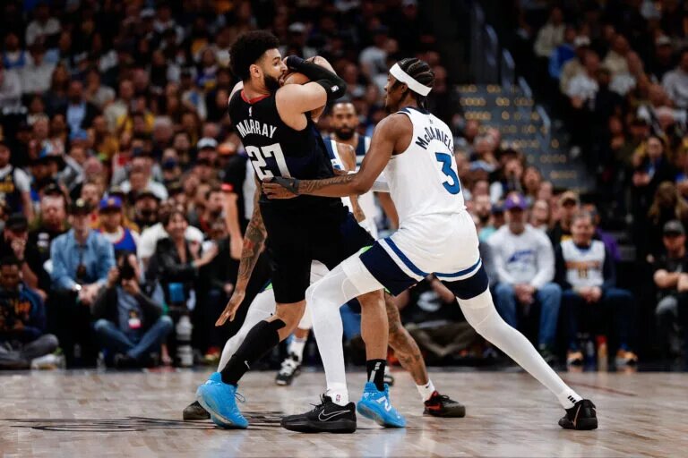 Minnesota Timberwolves forward Jaden McDaniels plays defense against Denver Nuggets guard Jamal Murray