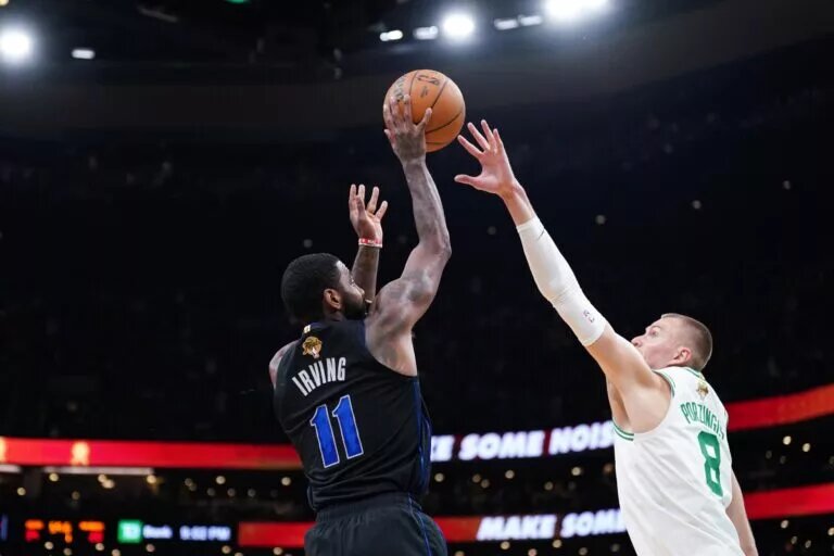Jun 6, 2024; Boston, Massachusetts, USA; Dallas Mavericks guard Kyrie Irving (11) shoots against Boston Celtics center Kristaps Porzingis (8) in the first quarter during game one of the 2024 NBA Finals at TD Garden. Mandatory Credit: David Butler II-USA TODAY Sports