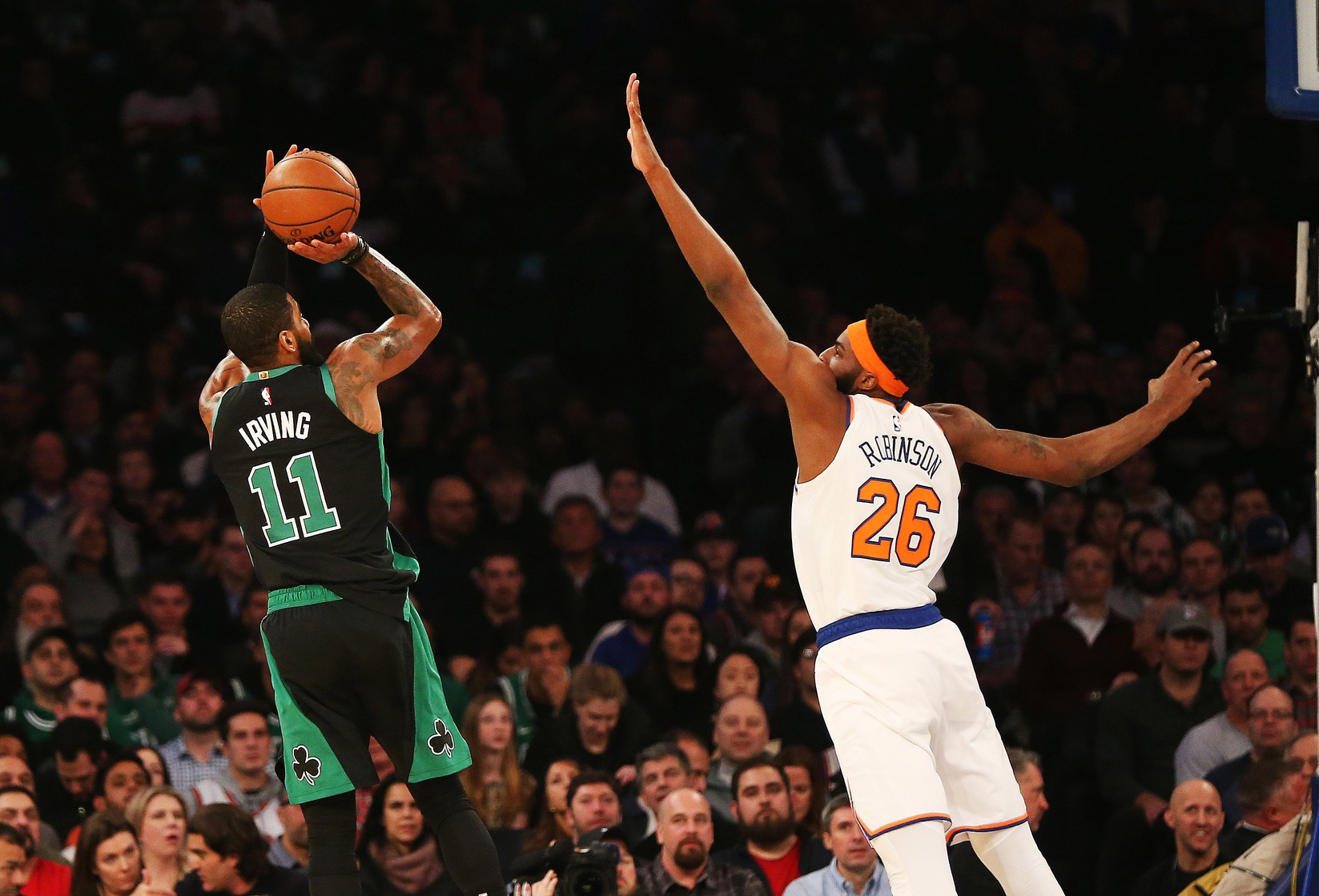 New York Knicks center Mitchell Robinson contests a shot by Kyrie Irving (formerly with Boston Celtics)