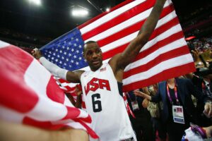 Team USA Basketball forward LeBron James (6) celebrates with an American flag at Olympics