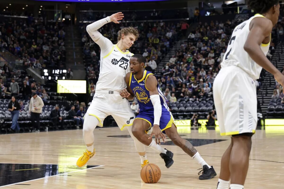 Golden State Warriors forward Jonathan Kuminga controls the ball as Utah Jazz forward Lauri Markkanen defends