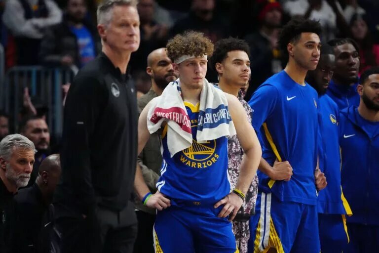 Golden State Warriors guard Brandin Podziemski stands beside head coach Steve Kerr by bench