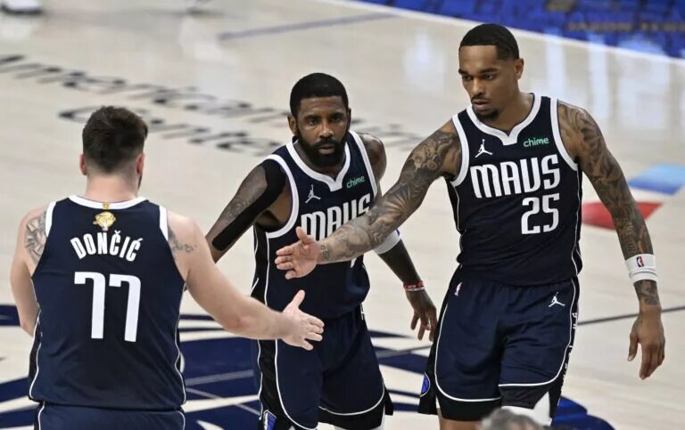 Dallas Mavericks guard Kyrie Irving (11) and forward P.J. Washington (25) celebrate with guard Luka Doncic (77)