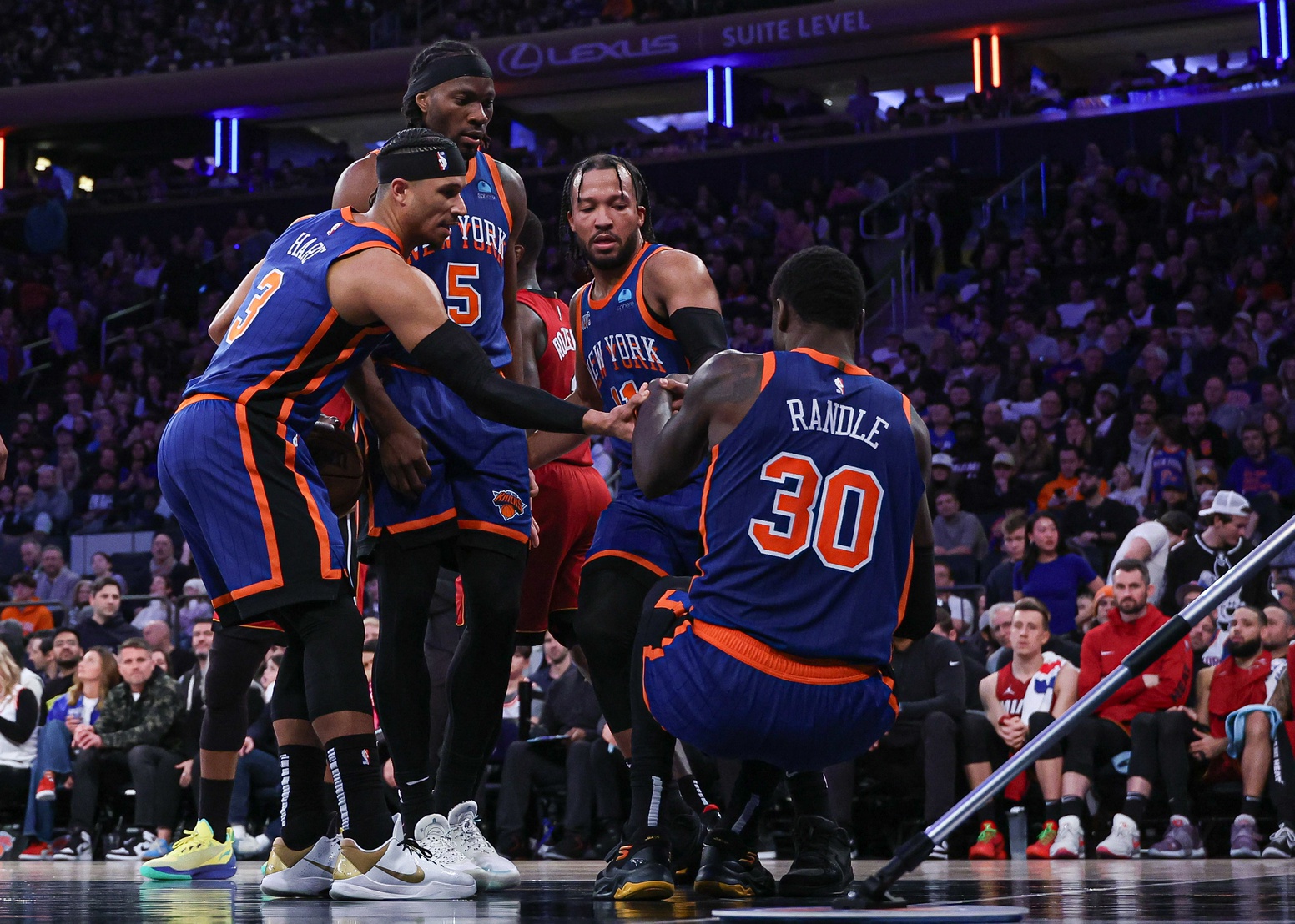 New York Knicks forward Julius Randle (30) is helped up by teammates after being injured during the second half against the Miami Heat at Madison Square Garden.