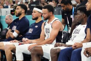 United States small forward Jayson Tatum (10), guard Devin Booker (15), shooting guard Stephen Curry (4) and guard Anthony Edwards (5) look on from the bench during the first half against Serbia in a men's basketball semifinal game during the Paris 2024 Olympic Summer Games at Accor Arena.