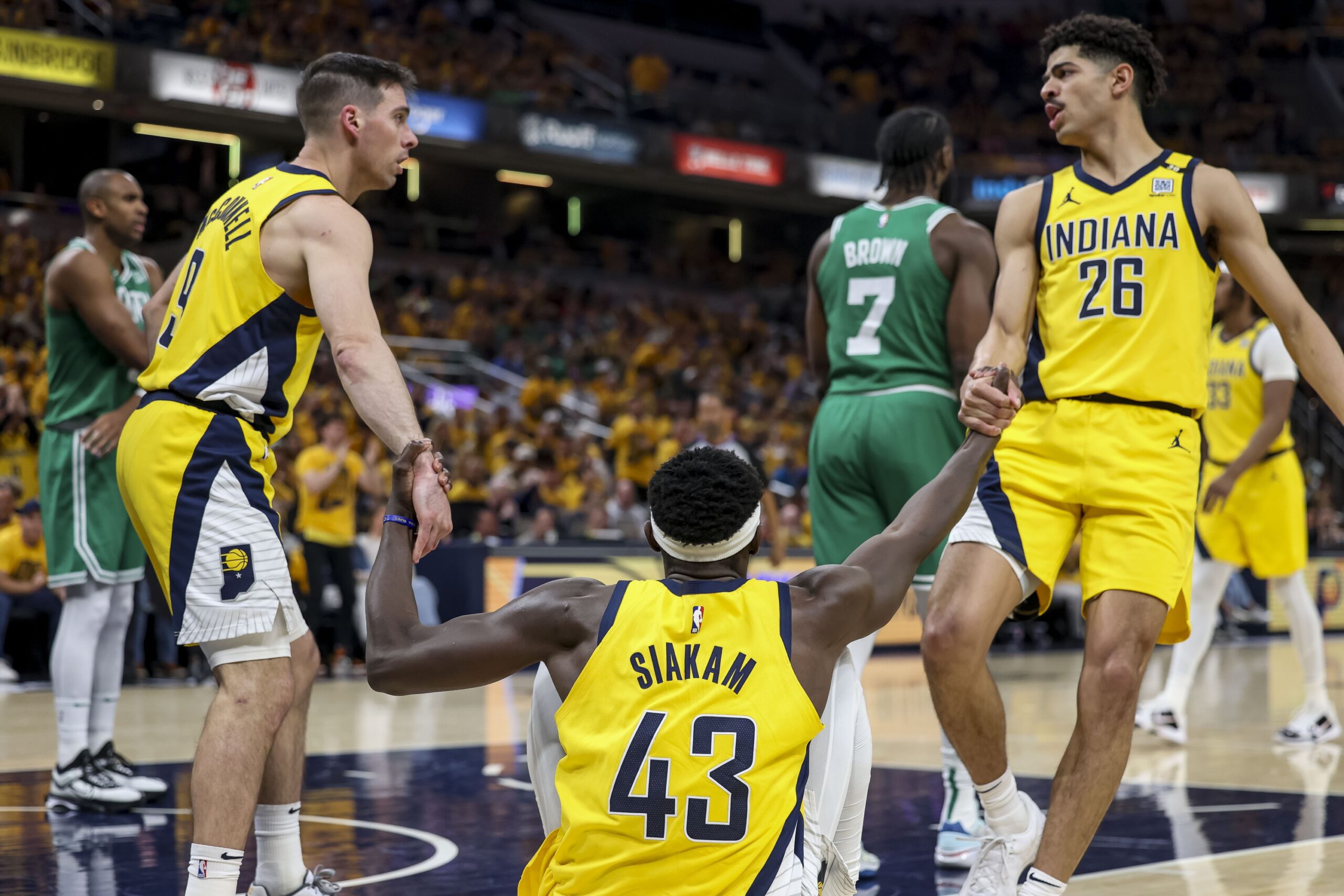 Indiana Pacers guard Ben Sheppard (26) and Indiana Pacers guard T.J. McConnell (9) help Indiana Pacers forward Pascal Siakam (43) stand up