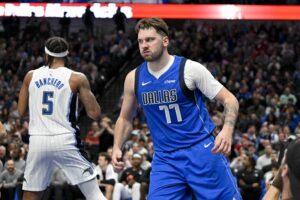 Dallas Mavericks guard Luka Doncic (77) reacts after scoring over former Duke Blue Devils and current Orlando Magic forward Paolo Banchero (5)