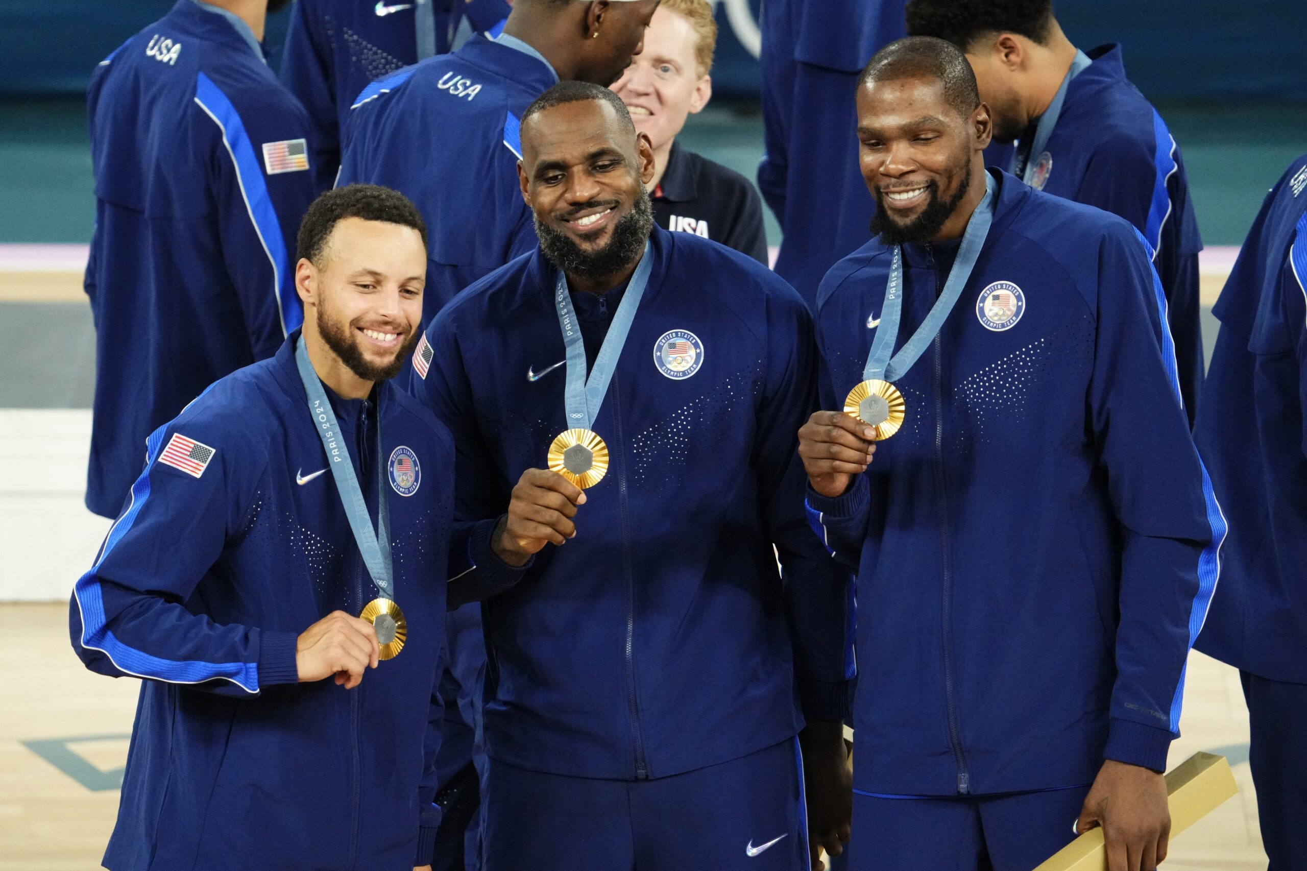 United States shooting guard Stephen Curry (Golden State Warriors) and guard LeBron James (Los Angeles Lakers) and guard Kevin Durant (Phoenix Suns) celebrate with their gold medals on the podium after defeating France in the men's basketball gold medal game during the Paris 2024 Olympic Summer Games