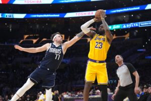 Jan 17, 2024; Los Angeles, California, USA; Los Angeles Lakers forward LeBron James (23) shoots the ball against Dallas Mavericks guard Luka Doncic (77) in the second half at Crypto.com Arena. Mandatory Credit: Kirby Lee-USA TODAY Sports