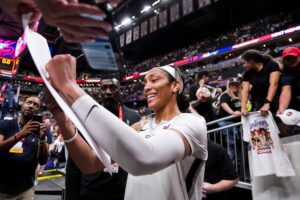 Las Vegas Aces center A'ja Wilson (22) signs a poster Friday, Sept. 13, 2024, during a game between the Indiana Fever and the Las Vegas Aces on Friday, Sept. 13, 2024, at Gainbridge Fieldhouse in Indianapolis. The Aces defeated the Fever, 78-74.