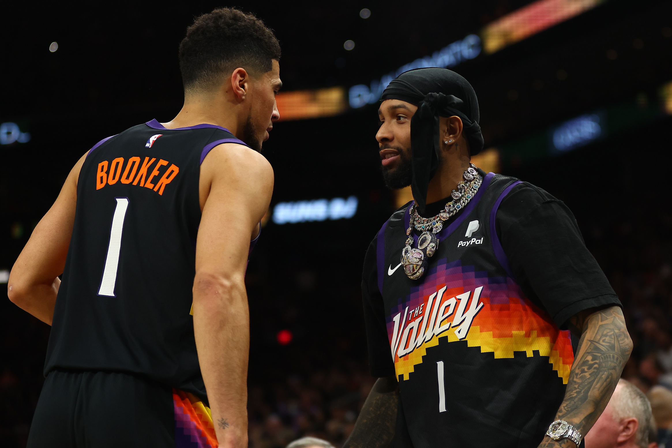 NFL player Odell Beckham Jr. greets NBA guard Devin Booker (1) during the first half