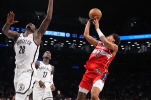 Oct 14, 2024; Brooklyn, New York, USA; bWashington Wizards shooting guard Jordan Poole (13) shoots a jump shot against Brooklyn Nets power forward Dorian Finney-Smith (28) and Brooklyn Nets point guard Dennis Schroder (17) during the second half at Barclays Center. Mandatory Credit: Gregory Fisher-Imagn Images