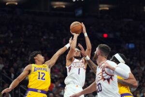 Oct 17, 2024; Phoenix, Arizona, USA; Phoenix Suns guard Devin Booker (1) shoots over Los Angeles Lakers guard Max Christie (12) during the first half at Footprint Center. Mandatory Credit: Joe Camporeale-Imagn Images