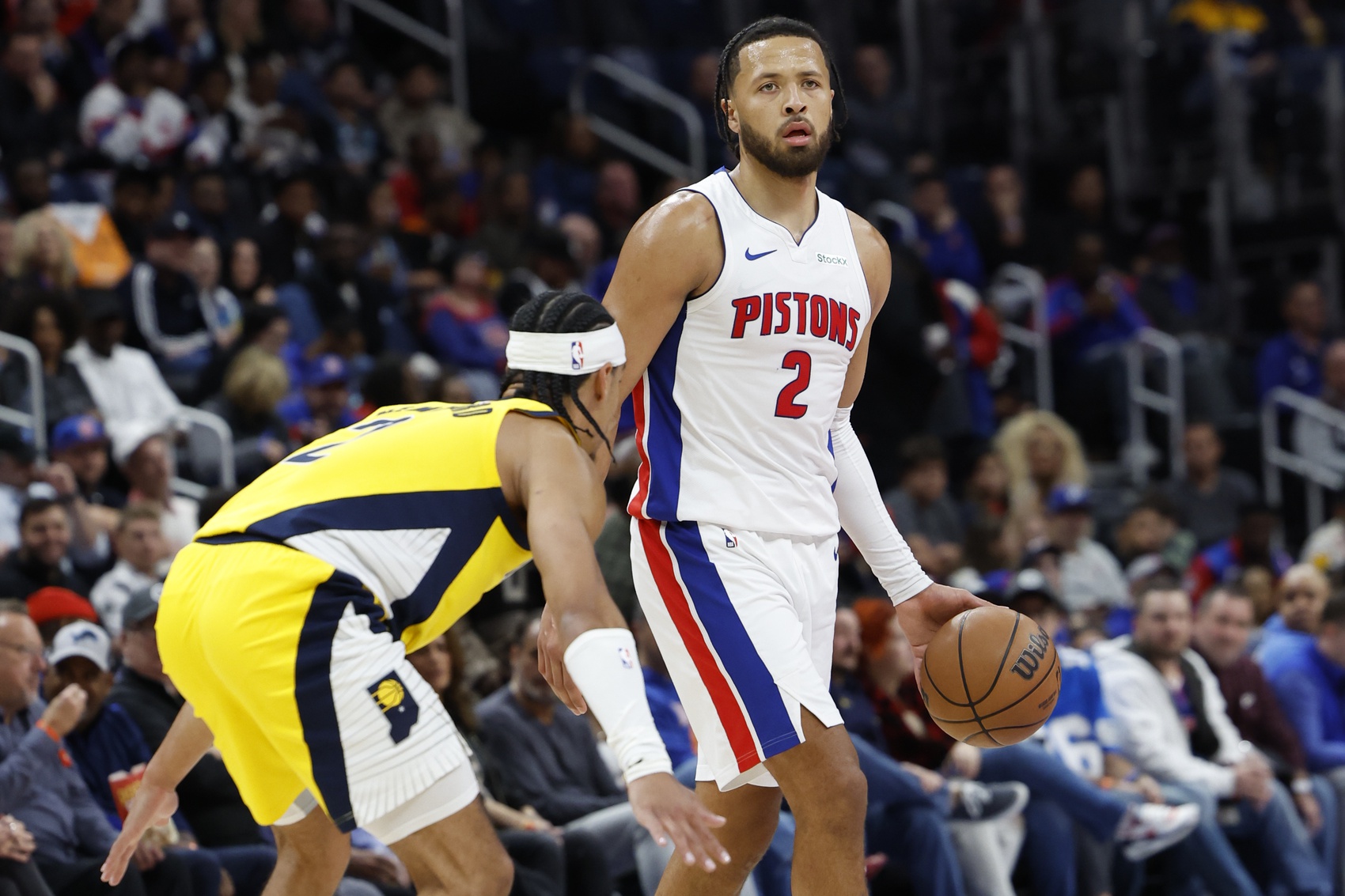 Detroit Pistons guard Cade Cunningham (2) dribbles defended by Indiana Pacers guard Andrew Nembhard (2) in the first half at Little Caesars Arena.